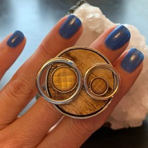 Upcycled statement pewter ring. Wooden base with some neutral sparkle.